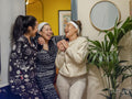 Women in pajamas standing and laughing at home