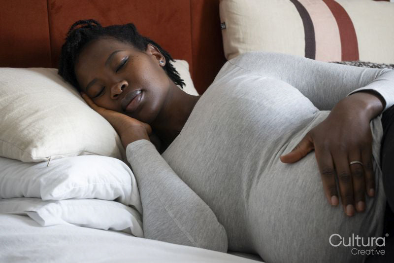 Pregnant woman sleeping on bed