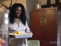Smiling woman carrying casserole dish with vegetables