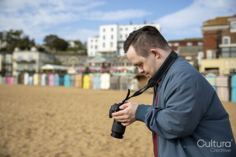 Mid adult man taking pictures on beach