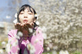 Portrait of young woman blowing flowers