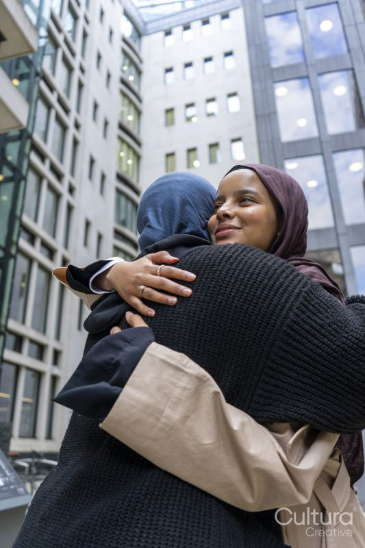 Two young women meeting in city
