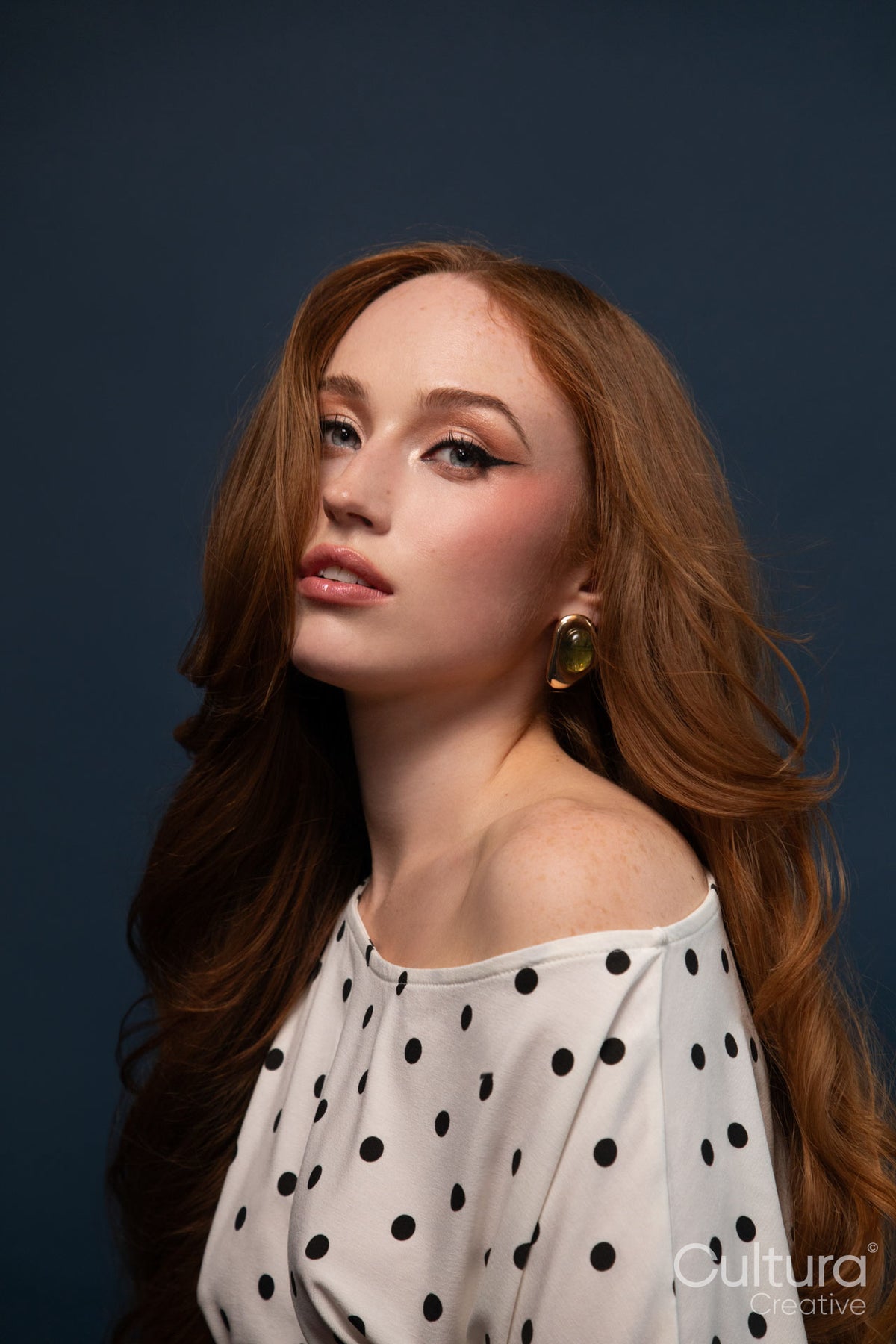 Studio portrait of a woman in a polka dot top with windswept hair