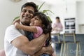 Father hugging daughter at home