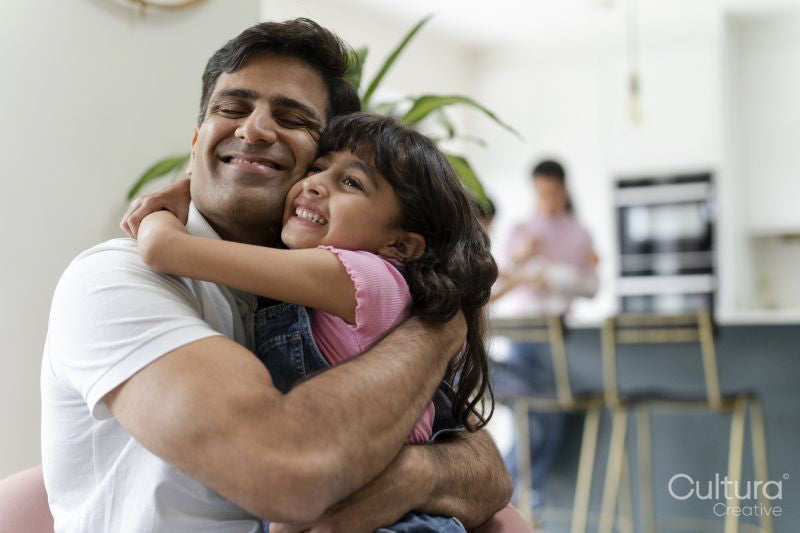 Father hugging daughter at home