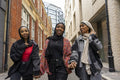 Three young women wearing hijabs walking in city