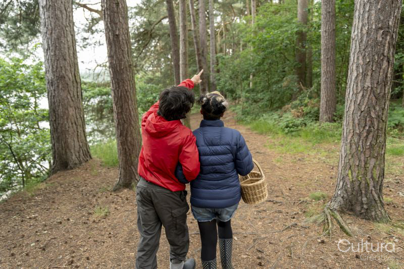 Mother and son walking in forest with basket