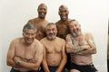 Portrait of smiling senior men without shirts against gray background