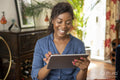 Smiling woman using digital tablet at home