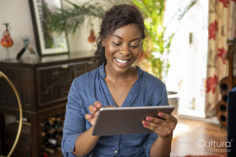 Smiling woman using digital tablet at home