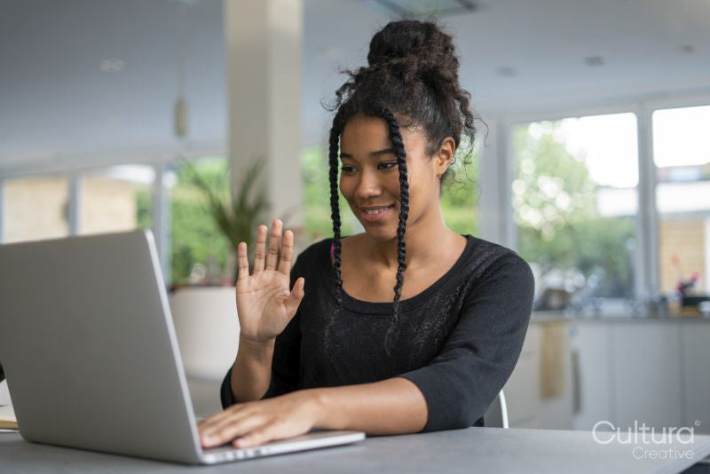 Teenage girl using laptop and waving