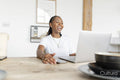 Cheerful woman working on laptop at home