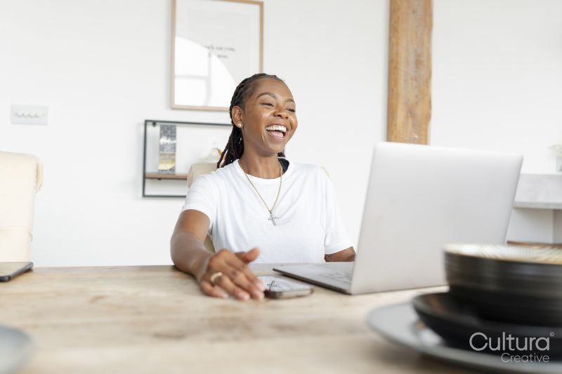 Cheerful woman working on laptop at home