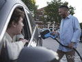 South Yorkshire, Smiling man charging electric car