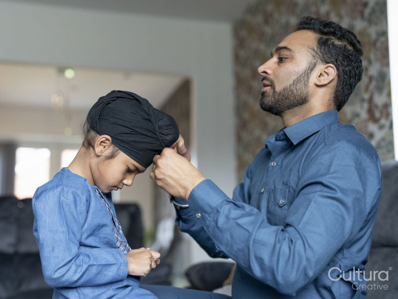 Father wrapping turban around son's head