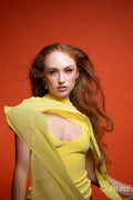 Woman in a yellow dress with windswept hair in a studio