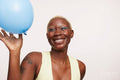 Smiling woman with short white hair, looking at blue balloon