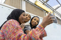 Smiling young women wearing hijabs taking selfie