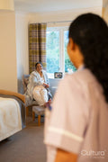 Nurse visiting senior lady in her room at nursing home
