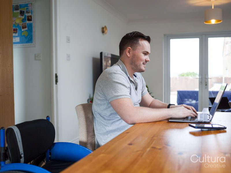Smiling man using laptop at home