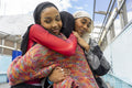 Young women wearing hijabs hugging in city