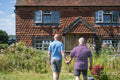 Senior male couple holding hands in garden