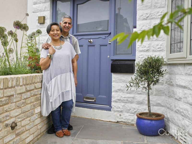 Portrait of couple standing in front of house
