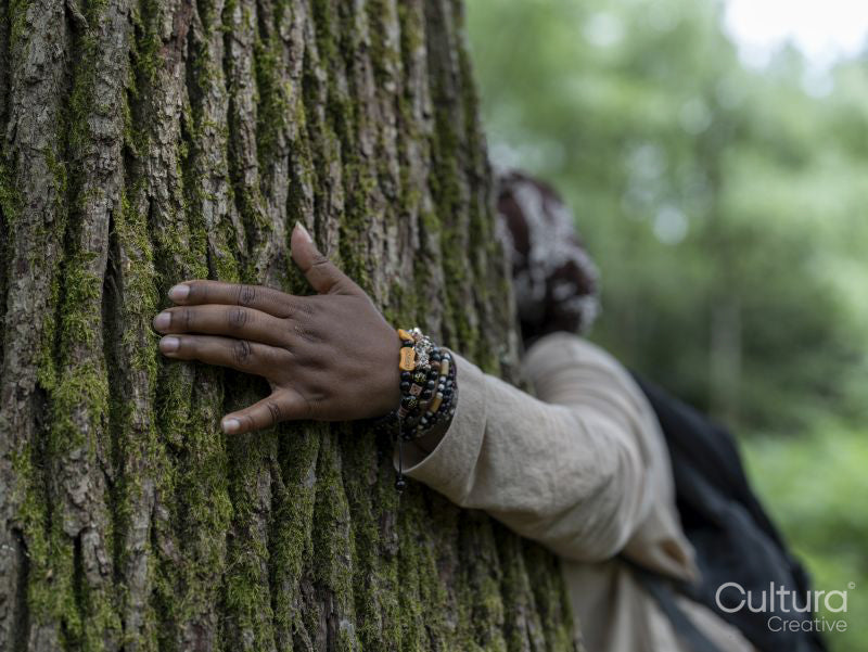 Hand of mature woman hugging tree
