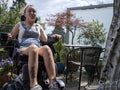 Woman in electric wheelchair relaxing on deck