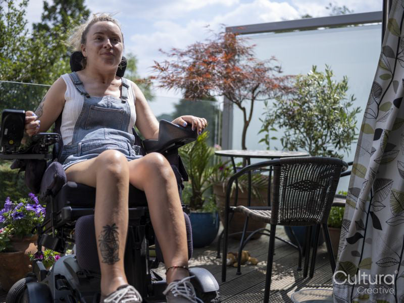 Woman in electric wheelchair relaxing on deck