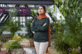Portrait of woman wearing headscarf standing in room full of houseplants
