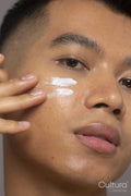Close-up of person applying moisturizer on face
