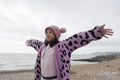 Girl standing with arms outstretched on beach