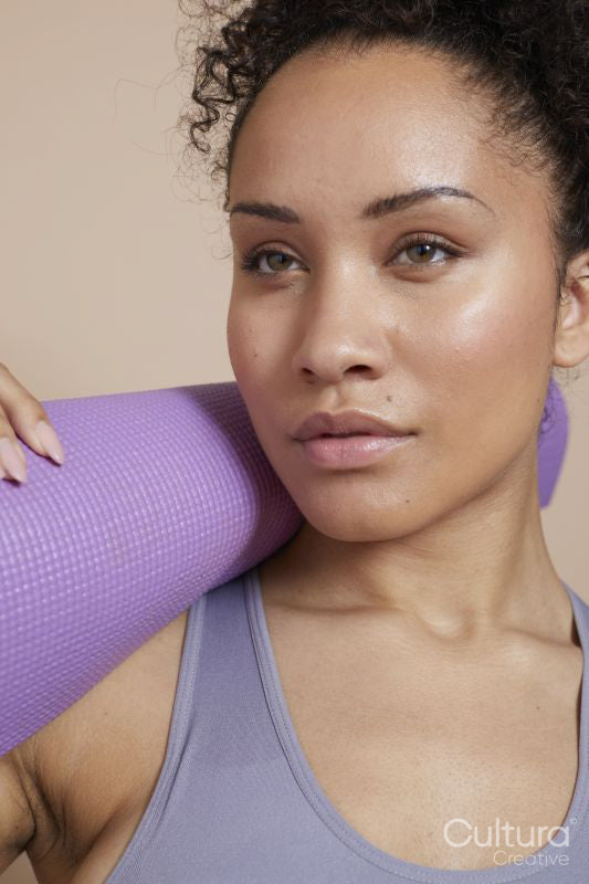 Close-up of athletic woman with yoga mat