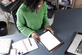 Concentrated businesswoman working on digital tablet by desk in office