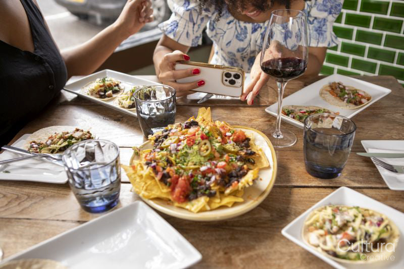 Close-up of woman photographing Me,ican food at restaurant table