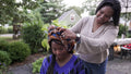 Mother putting traditional headdress on daughter
