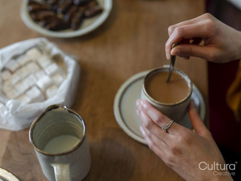 Woman stirring tea with milk