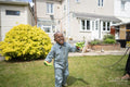 Boy splashed with water from garden hose