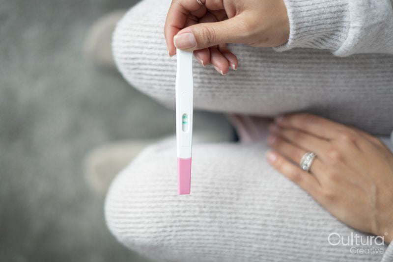 Woman checking pregnancy test, view from above