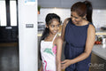 Mother tying daughters apron in kitchen