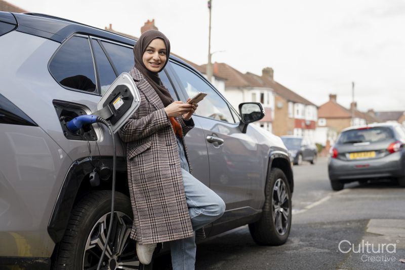 Woman wearing hijab charging electric car