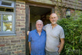 Portrait of senior male couple in front of house