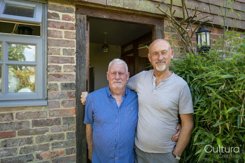 Portrait of senior male couple in front of house
