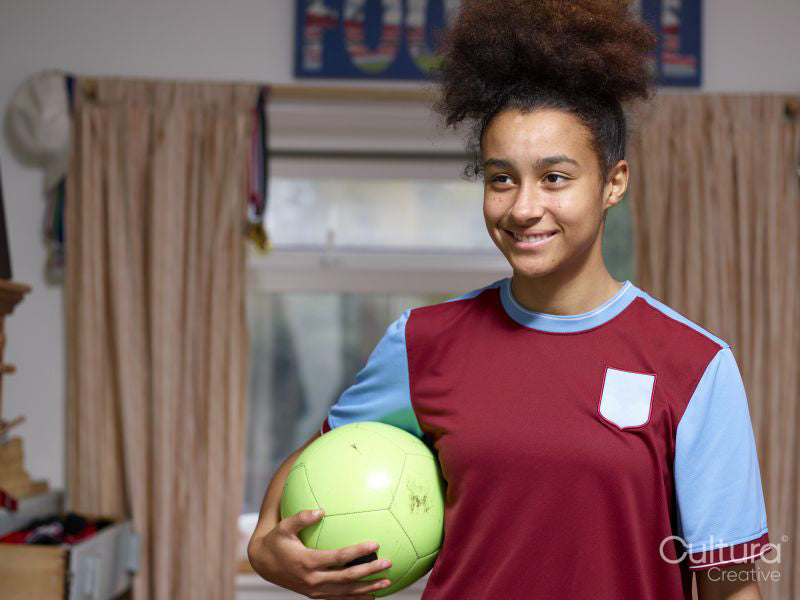 Smiling girl holding soccer ball