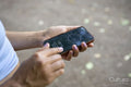 Young woman using compass on smart phone, close up of hands