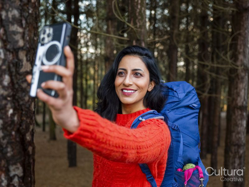 Smiling female hiker taking selfie in forest