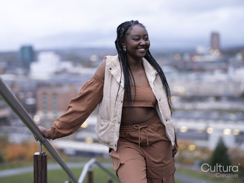 Smiling young woman standing on steps in city
