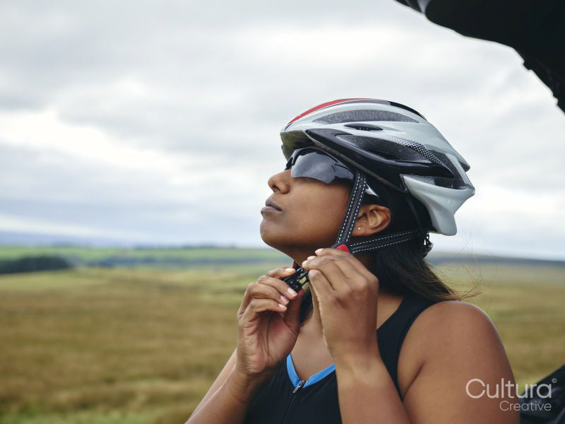 Woman putting on bicycle helmet