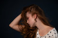 Woman in a polka dot top posing on a blue background